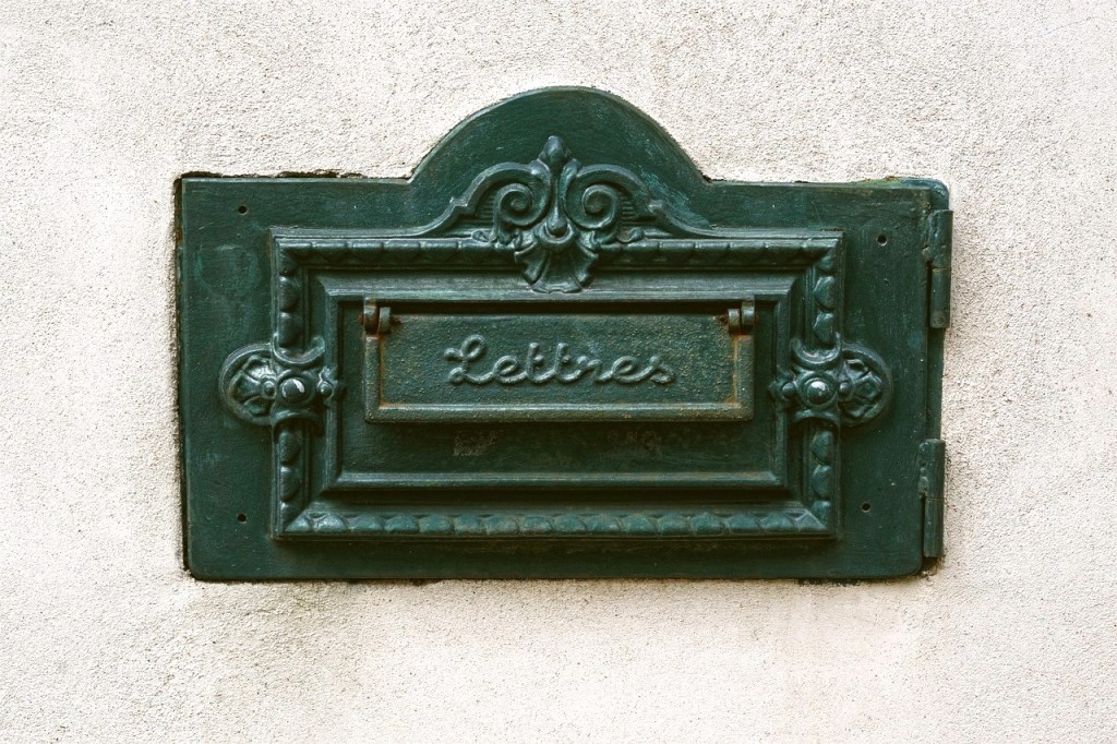Green letter mail slot with filigree and cursive "Lettres"